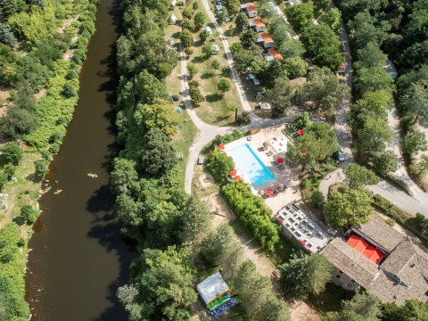 Vista aérea de Flower Camping Mas de Champel con piscina, río y áreas verdes en Auvergne-Rhône-Alpes, Francia.