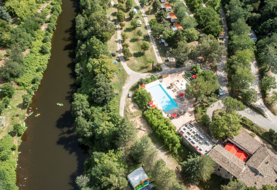 Luftaufnahme von Flower Camping Mas de Champel mit Pool, Fluss und grüner Landschaft in Auvergne-Rhône-Alpes, Frankreich.