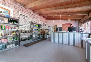 Reception og lille butik med lokale produkter på Flower Camping Mas de Champel, Auvergne-Rhône-Alpes, Frankrig.