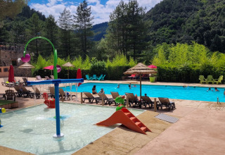 Piscina all’aperto con area bimbi e lettini al Flower Camping Mas de Champel in Auvergne-Rhône-Alpes.