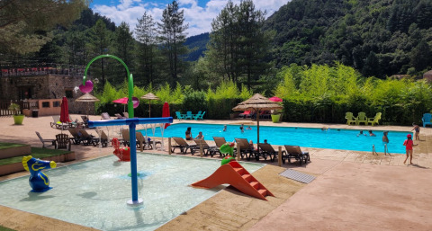 Udendørs swimmingpool med børneområde og solstole på Flower Camping Mas de Champel i Auvergne-Rhône-Alpes.