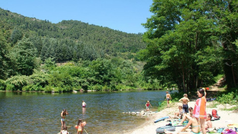 Familias y niños disfrutan junto al río en Flower Camping Mas de Champel en Auvergne-Rhône-Alpes, Francia.