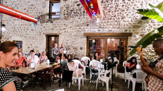 Soirée au Flower Camping Mas de Champel en Auvergne-Rhône-Alpes : les gens profitent de la musique en plein air.