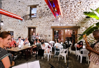 Aftenliv på Flower Camping Mas de Champel i Auvergne-Rhône-Alpes: folk nyder livemusik udendørs.