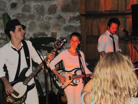 Liveband optræder på Flower Camping Mas de Champel i Auvergne-Rhône-Alpes, Frankrig, med folk foran scenen.