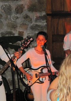 Live band performing at Flower Camping Mas de Champel, Auvergne-Rhône-Alpes, France, with audience watching.