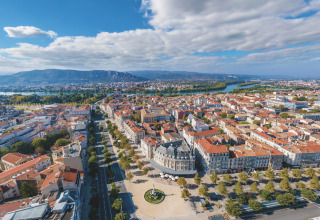 Vista aerea di una città vicino a Les Ollières sur Eyrieux, Auvergne-Rhône-Alpes, con fiume e montagne sullo sfondo.