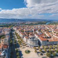 Vue aérienne d'une ville proche de Les Ollières sur Eyrieux, Auvergne-Rhône-Alpes, avec rivière et montagnes au loin.