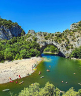 Pont naturel en pierre sur une rivière avec nageurs et kayaks près de Les Ollières sur Eyrieux, Ardèche, France.