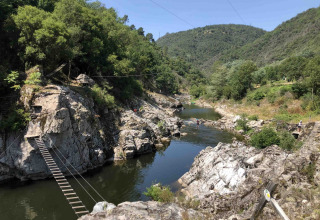 Scenic view of wooden bridges over a river at Flower Camping Mas de Champel in Auvergne-Rhône-Alpes, France.