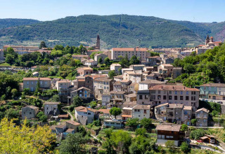 Vista panorámica de un pintoresco pueblo con colinas cerca de Flower Camping Mas de Champel en Auvergne-Rhône-Alpes.