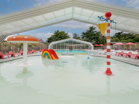 Overdekt kinderzwembad met kleurrijk speelgoed bij Flower Camping Les Paludiers, Pays de la Loire, Frankrijk.