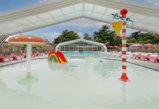 Piscine intérieure pour enfants avec jeux colorés au Flower Camping Les Paludiers, Pays de la Loire, France.