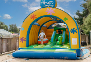Children playing on a colorful bouncy castle at Flower Camping Les Paludiers in Pays de la Loire, France.
