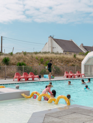 Außenpool mit Urlaubern im Flower Camping Les Paludiers, Ferienpark in Pays de la Loire, Frankreich.