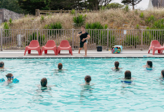 Ein Trainer leitet einen Wassergymnastikkurs im Pool bei Flower Camping Les Paludiers in Frankreich.