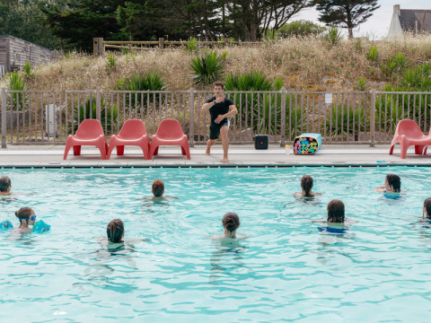 Un animateur dirige un cours d'aquagym à la piscine du Flower Camping Les Paludiers en France.