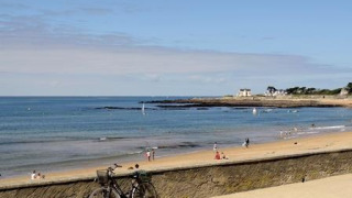 Zandstrand met fiets en wandelaars, een troef van Flower Camping Les Paludiers, Pays de la Loire, Frankrijk.