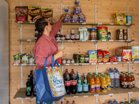 Vrouw winkelt in de supermarkt van Flower Camping Les Paludiers in Pays de la Loire, Frankrijk.
