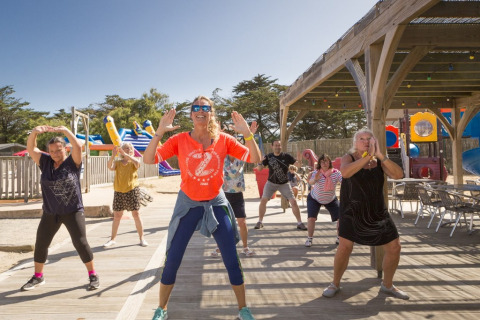 Volwassenen doen mee aan een zonnige outdoor fitnessles op Flower Camping Les Paludiers, Pays de la Loire.