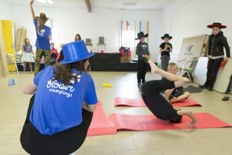 Kinderen doen binnen acrobatie en spelletjes op Flower Camping Les Paludiers, Pays de la Loire, Frankrijk.