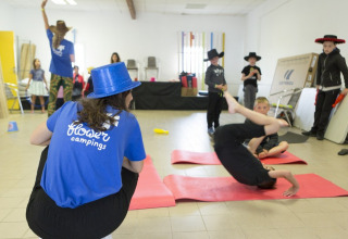 Children doing acrobatics and playing indoors at Flower Camping Les Paludiers, Pays de la Loire, France.