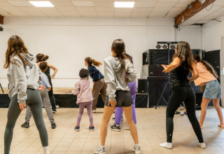 Kinder und Jugendliche tanzen gemeinsam in einem Kurs im Flower Camping Les Paludiers in Pays de la Loire, Frankreich.