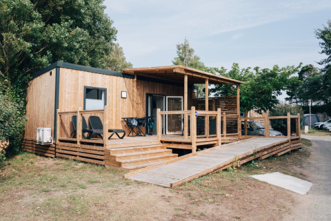 Holzhütte mit großer Terrasse und Rampe im Flower Camping Les Paludiers in Pays de la Loire, Frankreich.