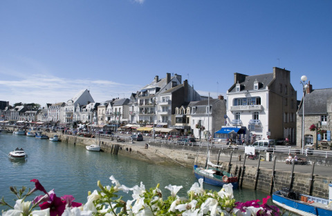 Vue sur le front de mer au Flower Camping Les Paludiers, Pays de la Loire, France, avec bateaux et fleurs.
