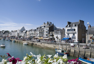 Vue sur le front de mer au Flower Camping Les Paludiers, Pays de la Loire, France, avec bateaux et fleurs.