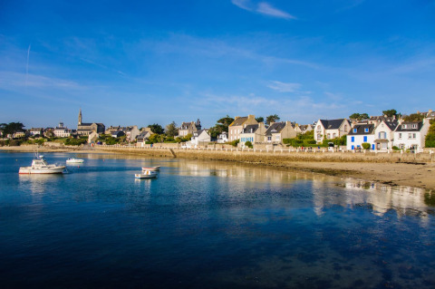 Coastal view of Flower Camping Les Paludiers holiday park in Pays de la Loire, France, with boats and houses.