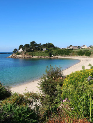 Zicht op een pittoreske baai nabij Batz sur Mer, Pays de la Loire, met zandstrand, tuinen en huizen.