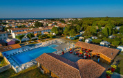 Luftaufnahme vom Flower Camping Le Bel Air mit Pool, Sonnenschirmen und Ferienhäusern in Nouvelle-Aquitaine, Frankreich.