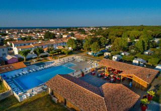 Luchtfoto van Flower Camping Le Bel Air met zwembad, ligstoelen en vakantieaccommodaties in Nouvelle-Aquitaine, Frankrijk.