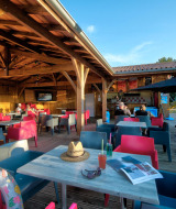 Gemütlicher Sitzbereich im Freien bei Flower Camping Le Bel Air, Nouvelle-Aquitaine, Frankreich, mit bunter Einrichtung.