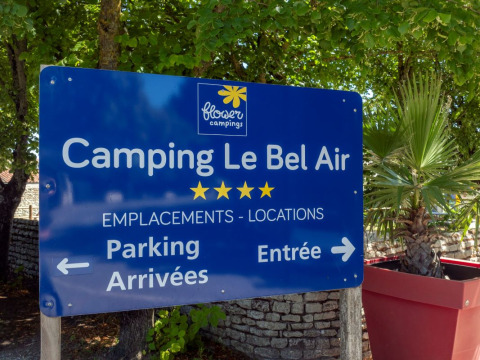 Cartel de Flower Camping Le Bel Air en Nouvelle-Aquitaine, Francia, indicando información de parking y entrada.