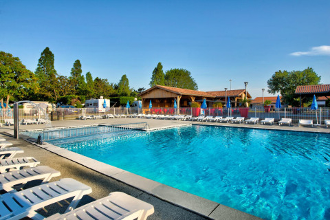 Udendørs swimmingpool og solstole ved Flower Camping Le Bel Air feriepark i Nouvelle-Aquitaine, Frankrig.