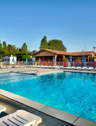 Außenpool mit Liegestühlen im Flower Camping Le Bel Air Ferienpark in Nouvelle-Aquitaine, Frankreich.