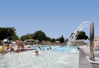 Bambini e famiglie giocano in piscina al Flower Camping Le Bel Air, un villaggio vacanze in Nouvelle-Aquitaine, Francia.