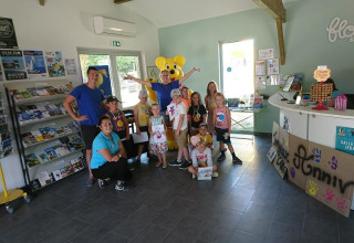 Kindergruppe mit Erwachsenen im Empfangsbereich von Flower Camping Le Bel Air in Nouvelle-Aquitaine, Frankreich.