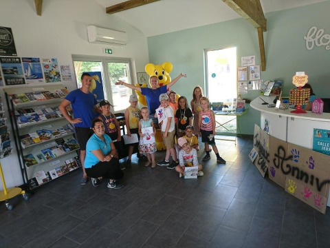 Group of children and adults at the reception of Flower Camping Le Bel Air in Nouvelle-Aquitaine, France.