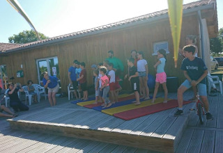 Børn og voksne deltager i aktiviteter udendørs på Flower Camping Le Bel Air, Nouvelle-Aquitaine, Frankrig.