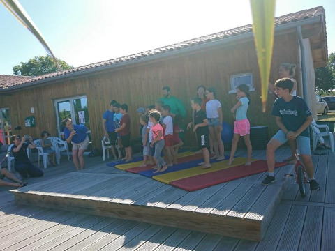 Kinder und Erwachsene nehmen an Aktivitäten auf Flower Camping Le Bel Air in Nouvelle-Aquitaine, Frankreich, teil.