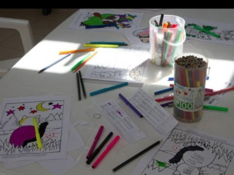 Crayons de couleur et coloriages éparpillés sur une table au Flower Camping Le Bel Air, Nouvelle-Aquitaine, France.