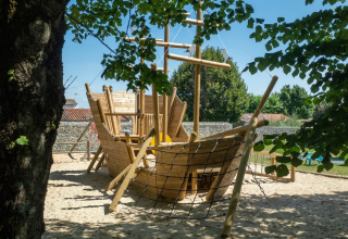 Playground with a large wooden ship in sand at Flower Camping Le Bel Air, Nouvelle-Aquitaine, France