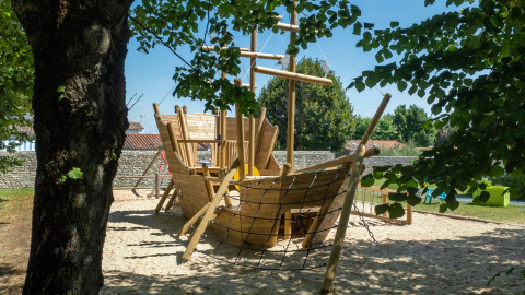 Speelplaats met groot houten schip in het zand bij Flower Camping Le Bel Air, Nouvelle-Aquitaine, Frankrijk
