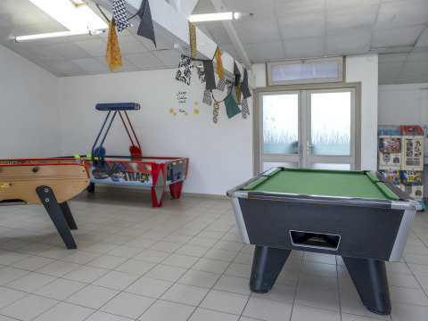 Sala de juegos con billar, hockey de aire, futbolín y máquinas de juguetes en Flower Camping Le Bel Air.