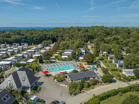 Luftfoto af ferieparken Flower Camping Le Kerleyou i Bretagne, Frankrig, med pool og mobilhomes.