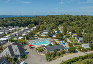 Luchtfoto van vakantiepark Flower Camping Le Kerleyou in Bretagne, Frankrijk, met zwembad en stacaravans.
