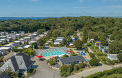 Vista aerea di Flower Camping Le Kerleyou in Bretagna, Francia, con piscina e case mobili nel verde.